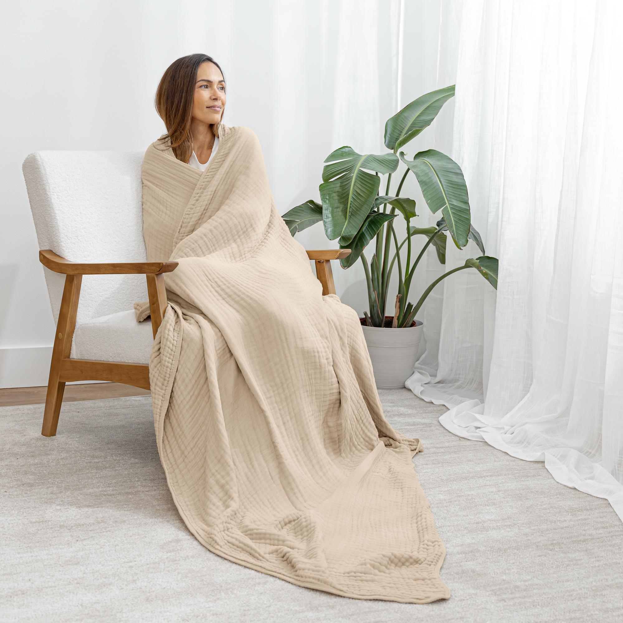Natural cotton muslin blanket draped over a lounge chair